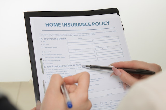 home insurance policy on a clipboard as someone fills it out
